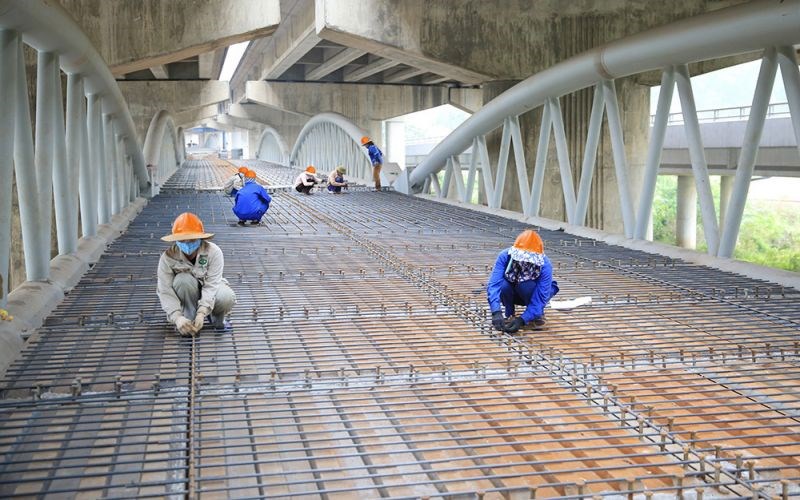 Hàng chục công nhân của nhà thầu đang khẩn trương thi công dự án cầu vòm sắt hồ Linh Đàm (nằm dưới đường Vành đai 3 trên cao) để bảo đảm tiến độ đề ra.	Ảnh: PV