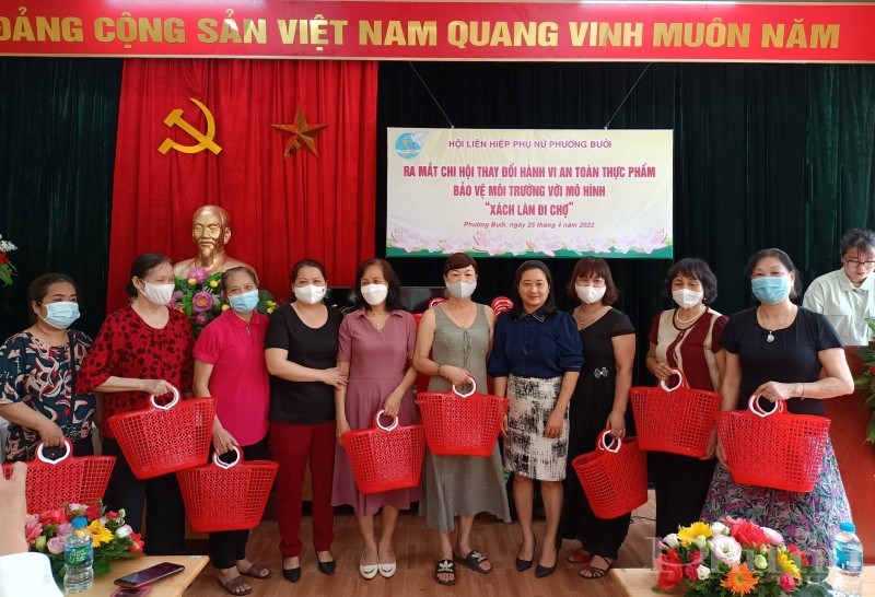 Đồng chí Lê Thị Thu Hằng - Phó Chủ tịch Hội LHPN quận Tây Hồ (thứ 7, từ trái qua) trao tặng làn nhựa đi chợ cho hội viên phụ nữ.