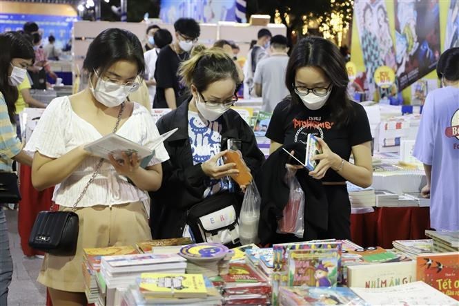 Độc giả trẻ chọn mua sách tại hội sách 	Ảnh: Hồng Giang/TTXVN