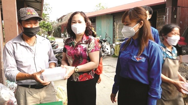 Đồng chí Nguyễn Thanh Mai, Chủ tịch Hội LHPN huyện Thanh Oai tặng hộp nhựa cho người dân đi chợ