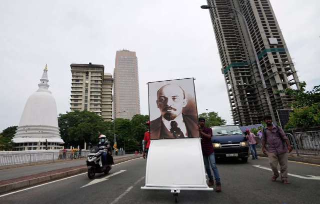 Các thành viên Đảng Xã hội tiền tuyến của Sri Lanka mang theo chân dung nhà cách mạng Vladimir Lenin trong cuộc tuần hành nhân kỷ niệm 1/5 ở Colombo, Sri Lanka.