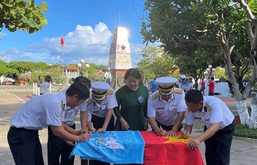 Cán bộ, chiến sĩ đảo Trường Sa trân trọng ký và viết lưu niệm lên lá cờ Tổ quốc và cờ Hội LHPN Việt Nam