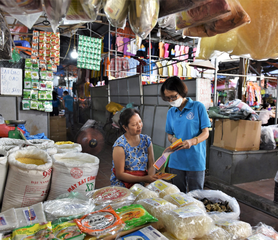 Cán bộ BHXH TP. Hà Nội thực hiện tư vấn, tuyên truyền cho người dân về BHYT, BHXH tự nguyện ở các chợ dân sinh.