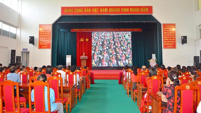 Cán bộ và nhân dân phường Tùng Thiện theo dõi diễu binh, diễu hành qua màn hình led